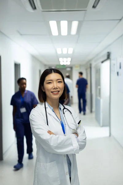 Verticaal Portret Van Lachende Aziatische Vrouwelijke Arts Drukke Ziekenhuisgang Kopieerruimte — Stockfoto