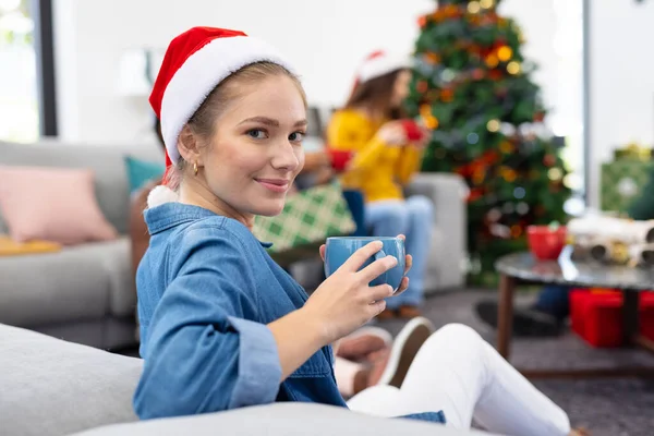 图片中的微笑的高加索女人拿着杯子 和朋友们在家里庆祝圣诞节 圣诞节 庆祝活动 包容和生活方式概念 — 图库照片