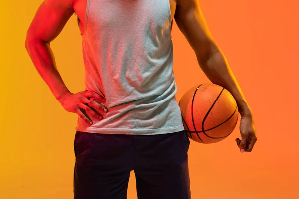 オレンジ色から黄色の背景にバスケットボールを持つ出生バスケットボール選手の中央部の画像 スポーツ 競技の概念 — ストック写真