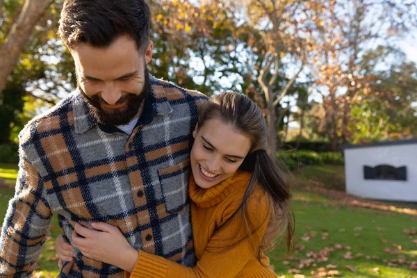 幸せな白人のカップルは晴れた秋の庭で笑顔と抱擁を歩いてください 国内生活 ロマンスと団結の概念 — ストック写真