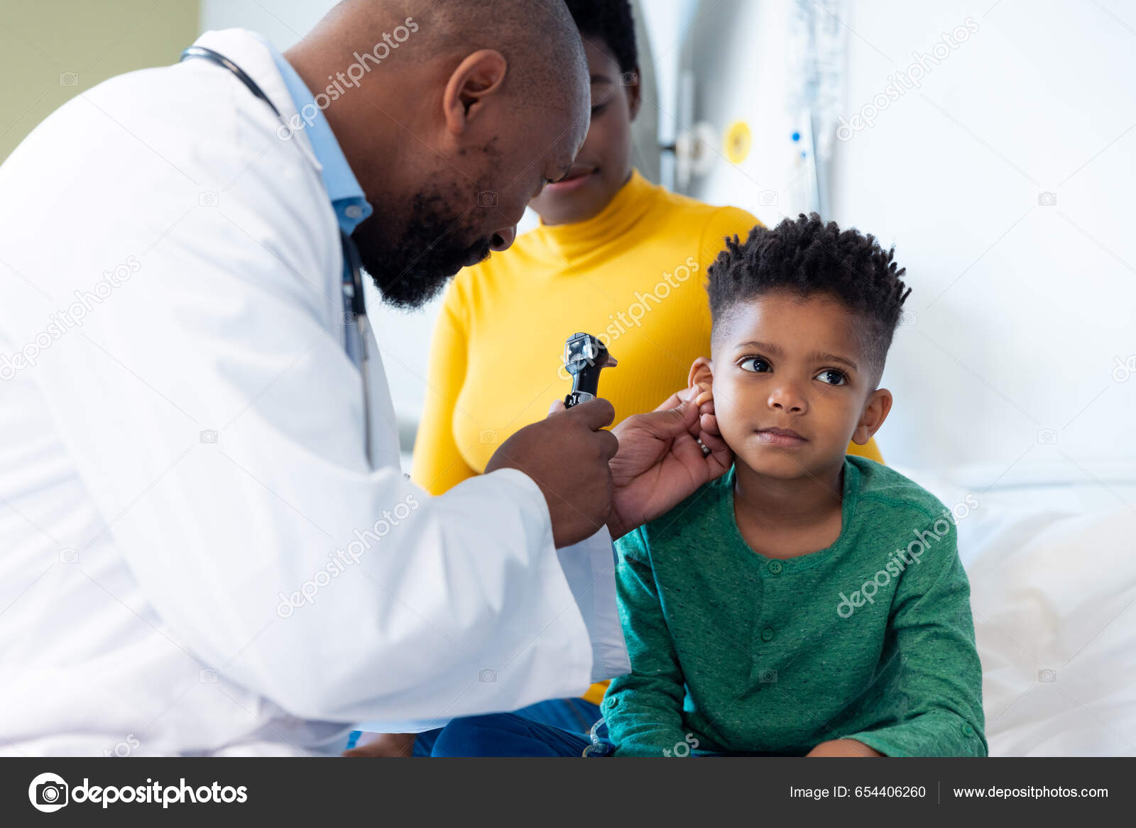 African American Male Doctor Using Otoscope Examine Ear Boy Patient