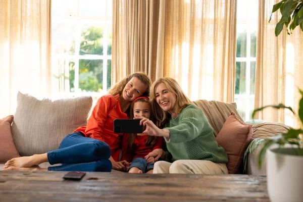 Imagen Mujeres Caucásicas Felices Tres Generaciones Sentadas Sofá Tomando Selfie —  Fotos de Stock