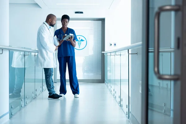 非裔美国男医生和女医生使用平板电脑 在医院走廊与复印空间交谈 医疗和保健服务 — 图库照片
