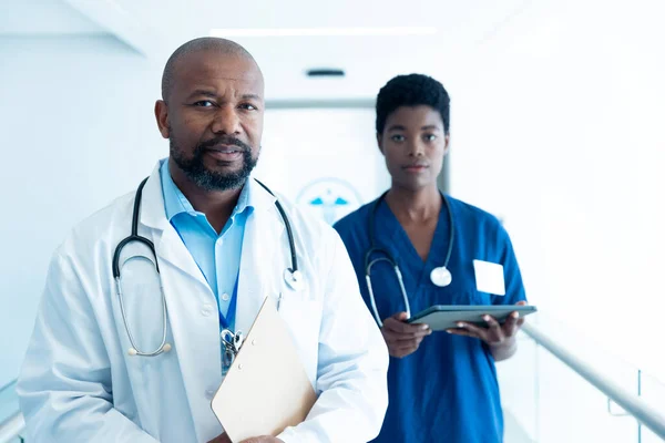 コピースペースと病院の廊下で深刻なアフリカ系アメリカ人男性と女性医師の肖像画 医療サービス — ストック写真