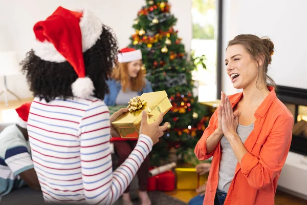 クリスマスにサンタの帽子や贈り物と幸せな多様な友人 クリスマス お祝い 包容力とライフスタイルの概念 — ストック写真
