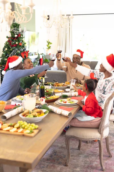 クリスマスの食事とワインを飲むアフリカ系アメリカ人の家族の垂直写真 クリスマス 家族の時間とお祝いの概念 — ストック写真