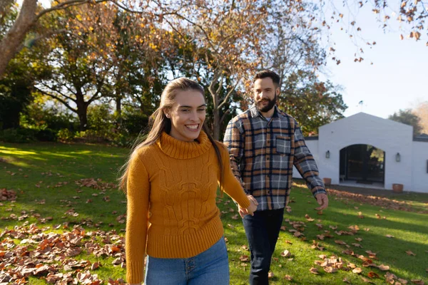 晴れた秋の庭を歩いて手をつないで幸せな白人夫婦 国内生活 ロマンスと団結の概念 — ストック写真