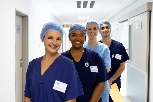病院の廊下で笑顔外科キャップを身に着けている医療従事者の多様なグループの肖像画 医療サービス — ストック写真