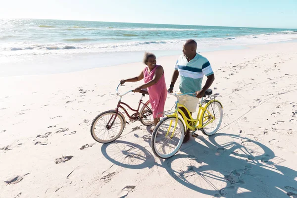 非洲裔美国老年夫妇骑自行车在海滩边聊天和散步的高视角图像 复制空间 自然和积极的生活方式 — 图库照片