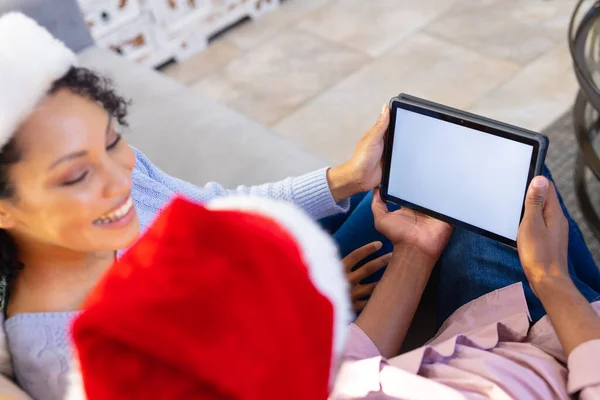 アフリカ系アメリカ人のカップルは コピースペースのタブレットを使用して サンタクラスの帽子を着用 一緒にクリスマスに質の高い時間を過ごす — ストック写真