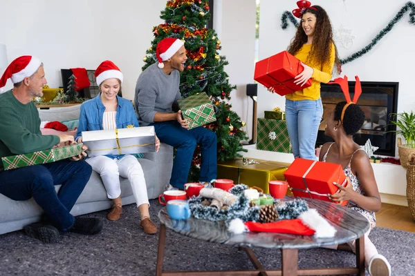 照片中快乐多样的朋友在家里交换礼物庆祝圣诞节 圣诞节 庆祝活动 包容和生活方式概念 — 图库照片