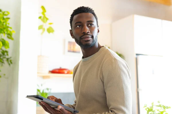 Szczęśliwy Afrykański Amerykanin Opierający Się Blat Kuchni Używając Tabletu Spędzanie — Zdjęcie stockowe