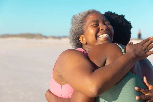 Alegre Afroamericana Madre Mayor Abrazando Hija Joven Mientras Disfruta Playa —  Fotos de Stock