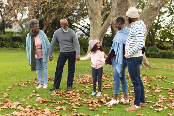 Image of happy multi generation african american family having fun outdoors in autumn. Extended family, spending quality time together concept.