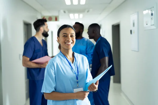 Retrato Uma Trabalhadora Saúde Birracial Sorridente Com Ficha Corredor Hospitalar — Fotografia de Stock