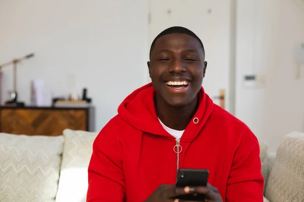 Smějící Afroameričan Sedí Doma Gauči Používá Smartphone Inkluzivita Domácí Život — Stock fotografie