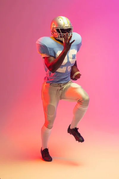 Africký Americký Fotbalista Drží Míč Neonově Růžovým Osvětlením Sport Pohyb — Stock fotografie