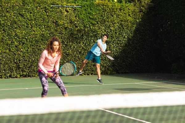在阳光灿烂的室外网球场打网球的年轻夫妇 包容性 健康爱好 健身和闲暇时间概念 — 图库照片