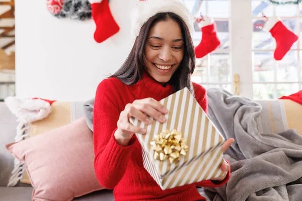 快乐的女人戴着圣诞礼帽 坐在客厅的沙发上 有视频通话 圣诞时独自在家度过美好的时光 — 图库照片