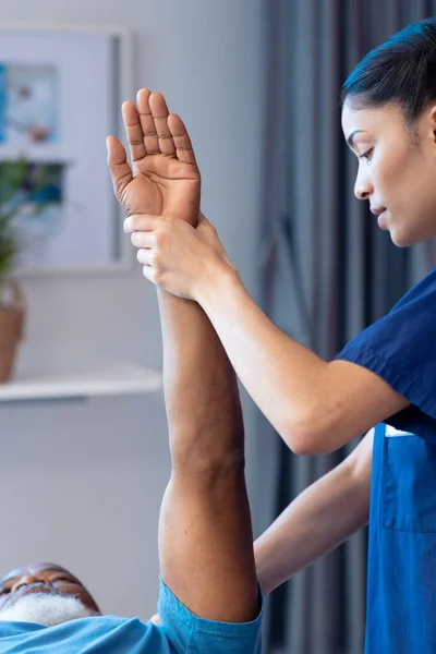 Vertikale Von Verschiedenen Weiblichen Physiotherapeutin Behandlung Arm Des Älteren Männlichen — Stockfoto