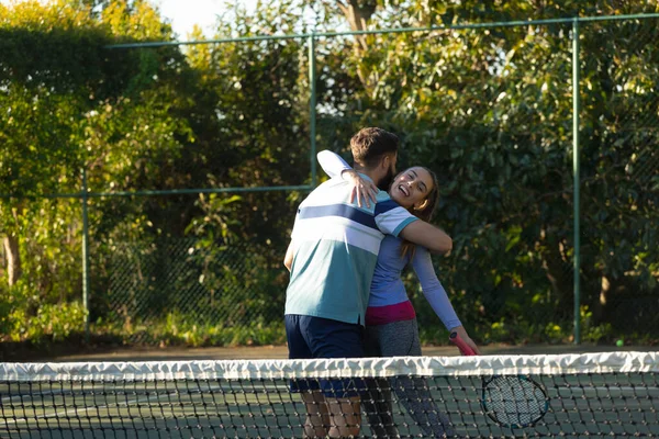 Ευτυχισμένο Καυκάσιο Ζευγάρι Που Παίζει Τένις Αγκαλιάζοντας Υπαίθριο Γήπεδο Τένις — Φωτογραφία Αρχείου