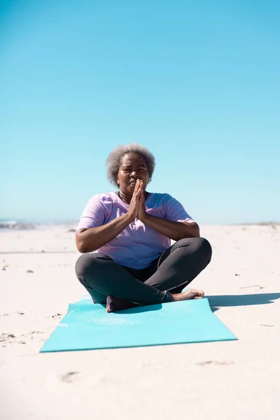 Mujer Mayor Afroamericana Con Piernas Cruzadas Meditando Alfombra Playa Contra —  Fotos de Stock