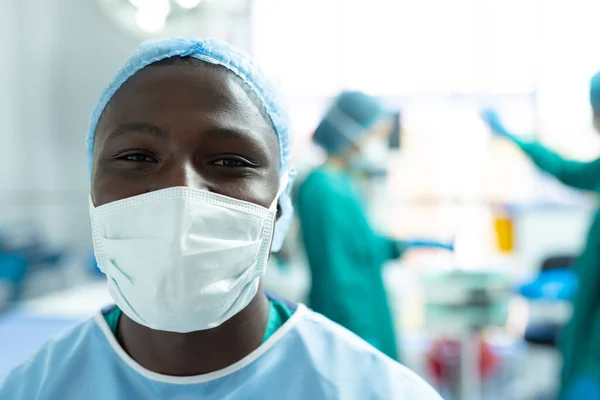コピースペースで 手術室で顔マスクでアフリカ系アメリカ人男性外科医の笑顔の肖像画 医療サービス — ストック写真