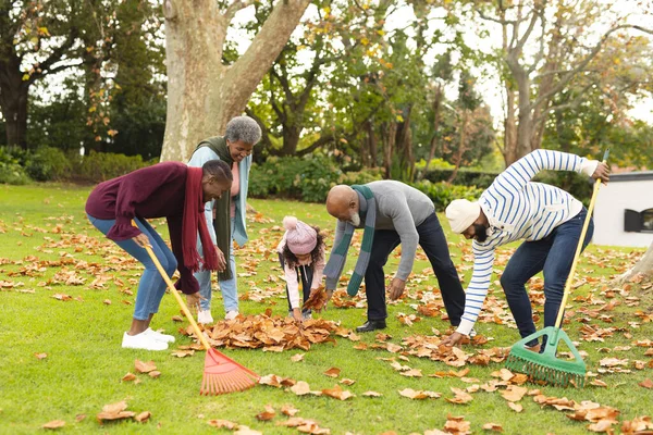秋の庭で葉をスワイプする幸せなアフリカ系アメリカ人の複数世代の家族のイメージ 家族と一緒に質の高い時間を過ごすコンセプト — ストック写真