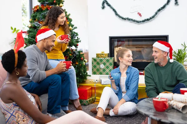 照片中快乐多样的朋友在家里庆祝圣诞节 聊着天 喝着热巧克力 圣诞节 庆祝活动 包容和生活方式概念 — 图库照片