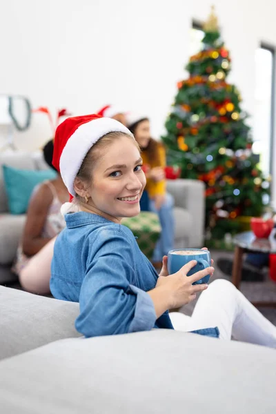 多様な友人と自宅でクリスマスを祝う笑顔の白人女性の垂直イメージ クリスマス お祝い 包括性とライフスタイルの概念 — ストック写真