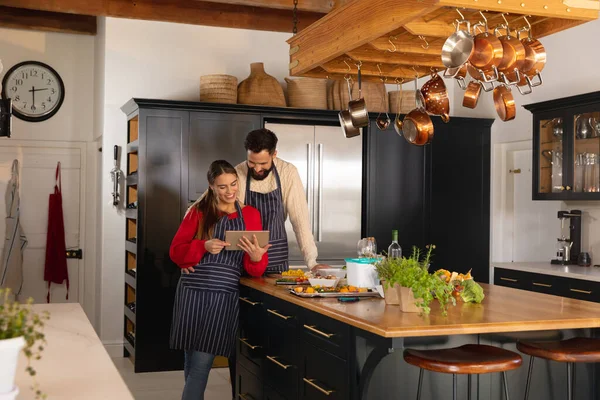 Mutfakta Yemek Hazırlayan Kucaklayan Tabletteki Tariflere Bakan Mutlu Beyaz Çift — Stok fotoğraf