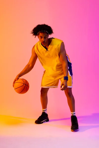 Obrázek Biracial Basketbalista Skákání Basketbal Růžovém Oranžovém Pozadí Sportovní Soutěžní — Stock fotografie