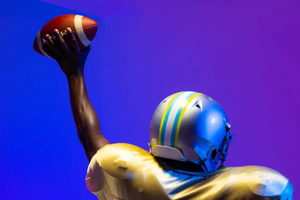 Amerykański Amerykański Futbolista Trzymający Piłkę Neonowym Niebieskim Oświetleniem Sport Ruch — Zdjęcie stockowe