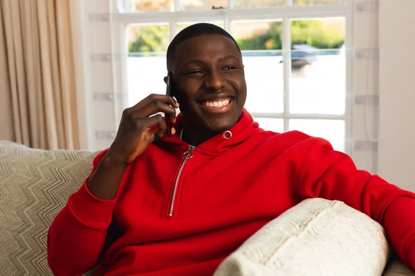 Homem Americano Africano Sorridente Sentado Sofá Casa Falando Smartphone Inclusividade — Fotografia de Stock
