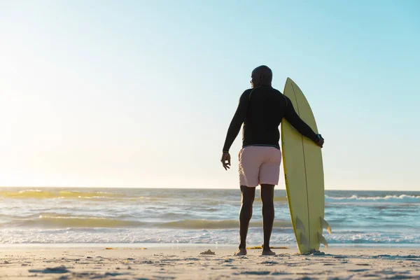 非洲裔美国老人的后视镜 他带着冲浪板 在日落时凝视着海景和晴朗的天空 复制空间 水上运动 — 图库照片