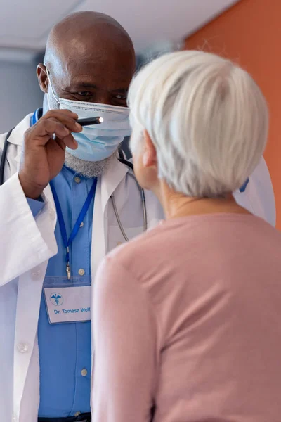 Vertical Diverse Senior Male Doctor Examining Eye Female Patient Penlight — Photo