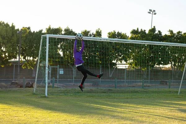 Afrykański Amerykański Bramkarz Podniesionymi Ramionami Skaczący Łapiący Piłkę Powietrzu Kopiuj — Zdjęcie stockowe