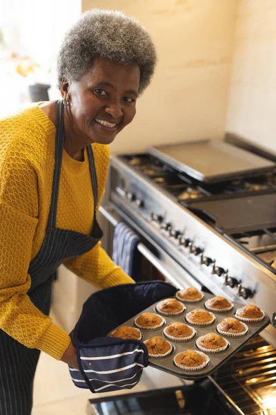 할머니가 오븐에서 케익을 꺼내는 모습을 수직으로 빵굽기 에서의 시간보내기 — 스톡 사진