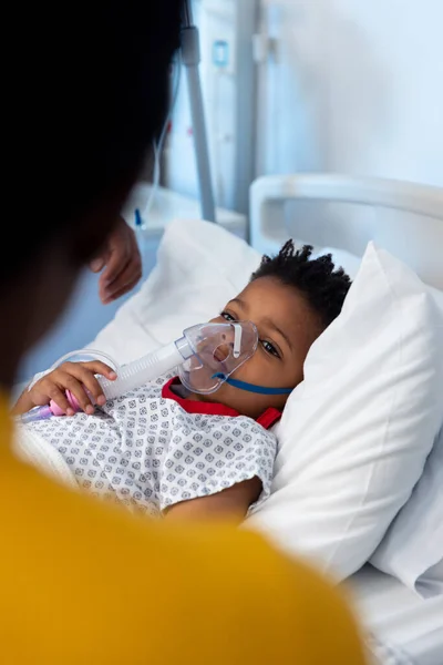 病院の人工呼吸器マスクのアフリカ系アメリカ人の息子の患者 コピースペースを持つ母親を探して 医療サービス — ストック写真