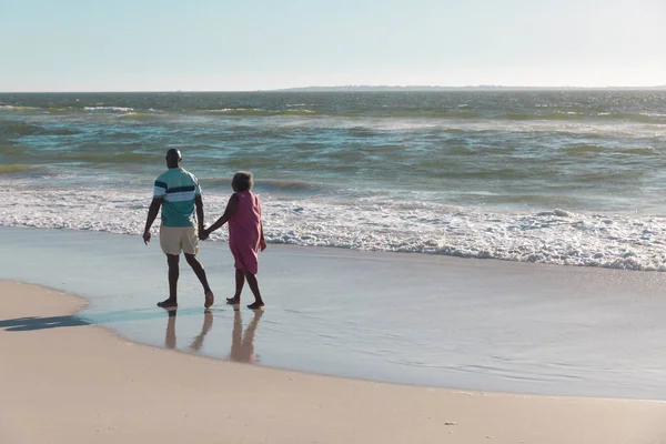 アフリカ系アメリカ人のシニアカップルの手を握り 澄んだ空の下で海岸を歩くの背面ビュー コピースペース ビーチ 変更されていない 一緒に 楽しさと自然 — ストック写真