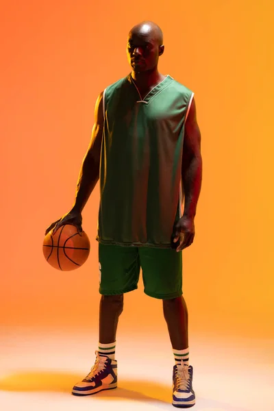 Obraz Afrykańskiego Koszykarza Amerykańskiego Koszykówką Neonowym Pomarańczowym Tle Koncepcja Sportu — Zdjęcie stockowe