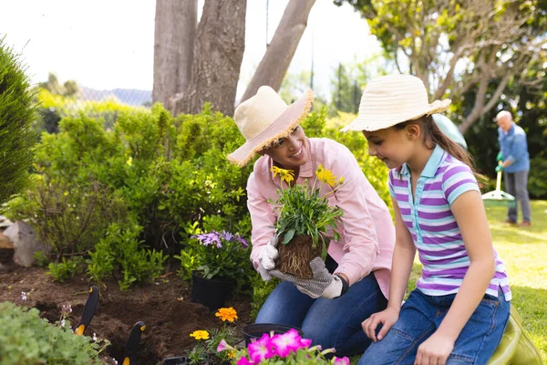 白种人的母亲和女儿一起在花园里种花 家庭外出时间 — 图库照片