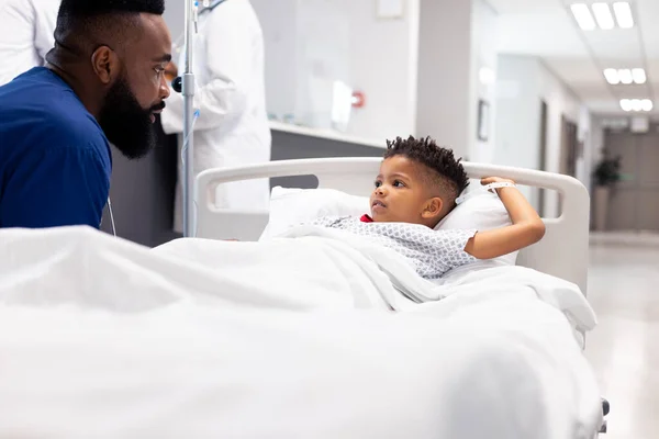 Αφροαμερικάνος Γιατρός Μιλάει Ασθενή Στο Κρεβάτι Του Νοσοκομείου Στο Διάδρομο — Φωτογραφία Αρχείου
