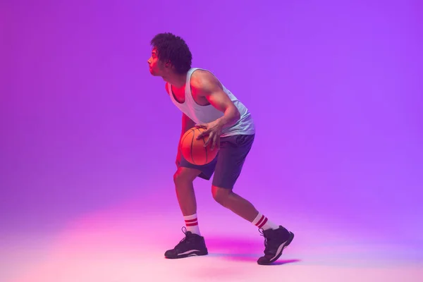ネオンパープルを背景にしたバスケットボール選手のイメージ スポーツ 競技の概念 — ストック写真