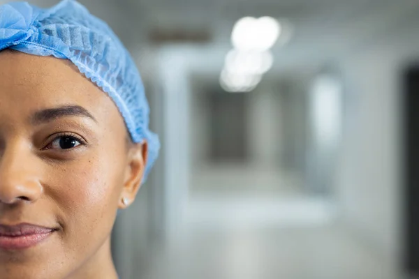 Portret Połowy Twarzy Uśmiechniętej Dwurasowej Pracowniczki Służby Zdrowia Korytarzu Szpitalnym — Zdjęcie stockowe