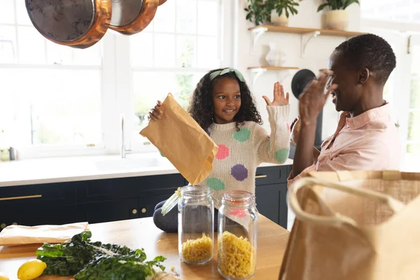 Imagen Madre Hija Afroamericanas Felices Desempacando Bolsas Compras Cocina Familia —  Fotos de Stock