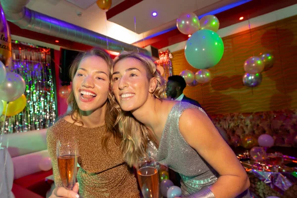 Dos Amigas Caucásicas Felices Abrazando Bebiendo Copas Champán Club Nocturno —  Fotos de Stock