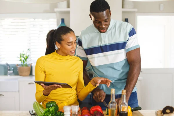 キッチンで一緒に料理を準備するタブレット上のレシピを使用して幸せな多様なカップル コミュニケーション 国内生活 愛と包括的な概念 — ストック写真