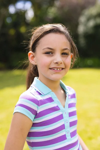 年轻的高加索女孩穿着条纹T恤站在花园里的垂直肖像 在概念之外单独度过时间 — 图库照片