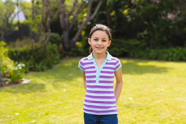 年轻的高加索女孩穿着条纹T恤站在花园里的画像 在概念之外单独度过时间 — 图库照片